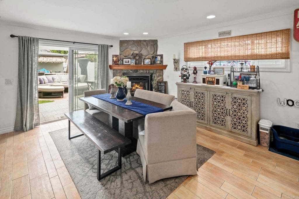 A dining room anchored by stone fireplace and garden views (as-is)